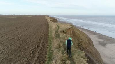 Man walking along the cliff edge