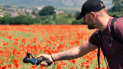 Photographer in field of poppies