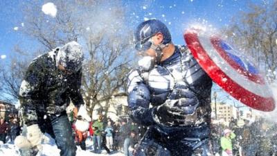 Jeff Dacanay (C), while dressed as Captain America, is pelted with snow during a snowball fight following a blizzard, at Dupont Circle in Washington, DC