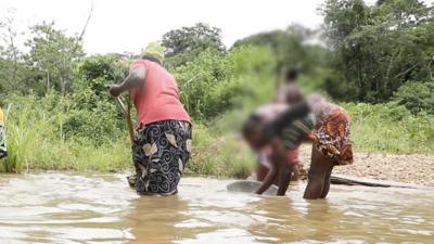 Women in the river looking for gold