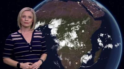 Sarah Keith-Lucas stands in front of a satellite chart over Africa