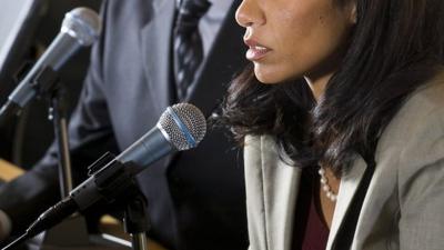 A woman talking into a microphone