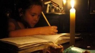 A girl does her homework by candlelight at her home during a power cut in San Cristobal, in the state of Tachira, Venezuela, 25 April 2016