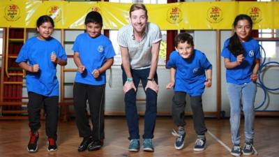 Ricky Wilson helps some kids to exercise