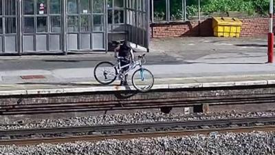 Teenager throwing bike onto railway line