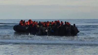 A crowded migrant boat setting sail from Calais in France