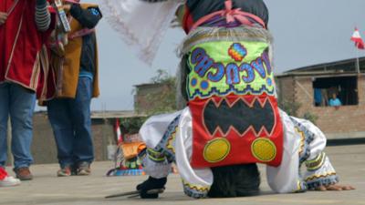 A scissor dancer balances on his head