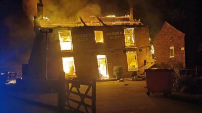 Crooked House Pub on fire with roof destroyed