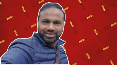 Dr Abdul Mannan in front of a red background with vaccine syringes