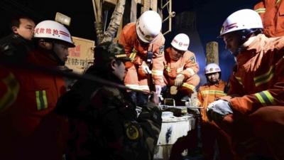 Rescuers try to contact the trapped people at a collapsed mine in Pingyi County, east China's Shandong Province