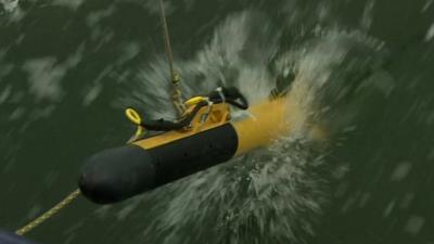 A towfish, or deep-water detector, being launched