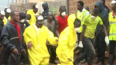 Rescue workers in Freetown carry a stretcher