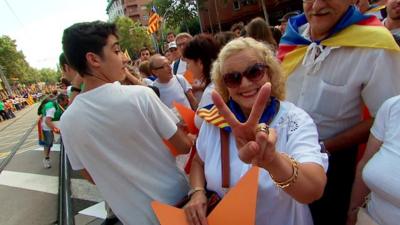 Woman in crowd giving 'peace' sign