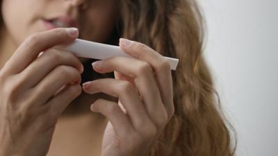 A woman looks at the result on a pregnancy test