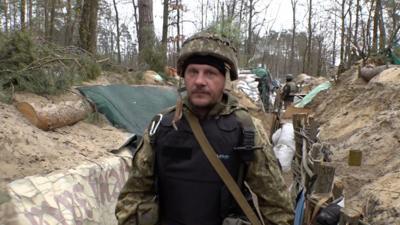 Ukrainian soldier walks through trenches outside Kyiv