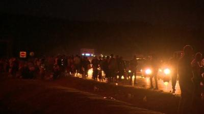 Migrants walking along side of road towards Austria