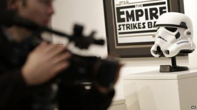 A camera man takes pictures of toys and other memorabilia from the "Star Wars" movie series on display during a press preview at Sotheby"s in New York