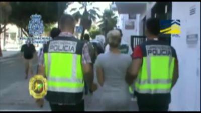 A woman is led away by police