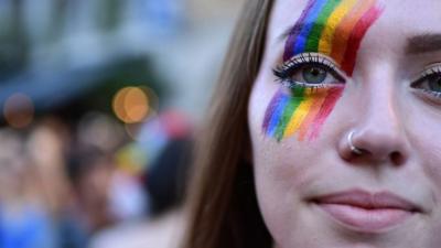 A woman with rainbow make up at a gay pride march