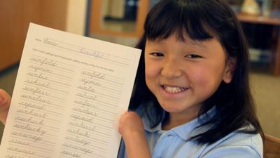 Girl with no hands hold up paper