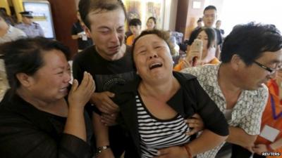 Crying mother of missing firefighter, helped by family