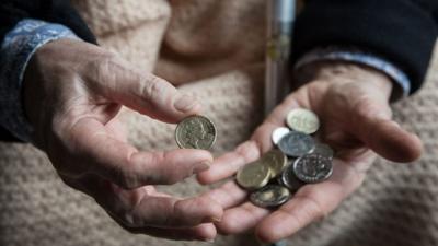 Elderly woman holding coins