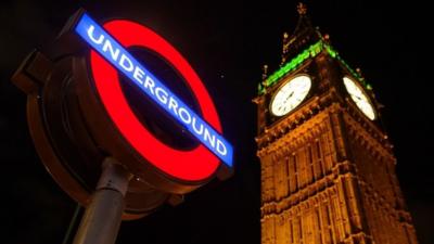 London Underground sign against the night sky and Big Ben