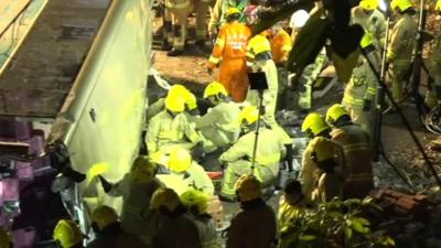 Firefighters try to free people trapped in the bus