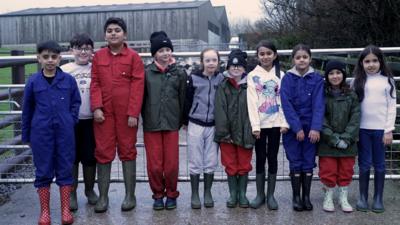 Children stood in a line on a farm