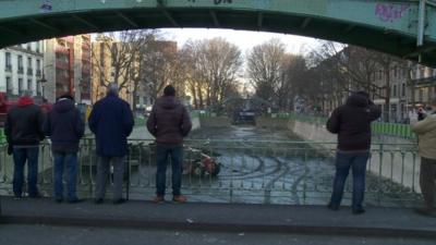 A crowd gathers at Canal Saint Martin