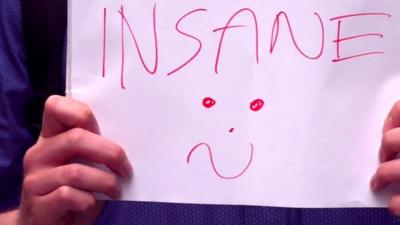 Person holding sign saying insane