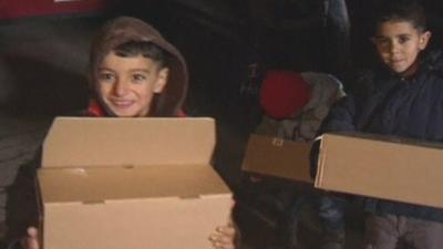 Refugee children holding gifts donated by local charity in Mulheim, Germany