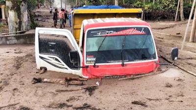 A truck buried in mud and ash