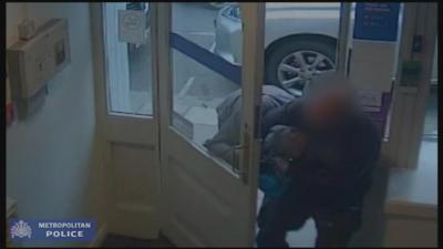 CCTV footage of a member of the public wrestling with an armed bank robber has been released by police.