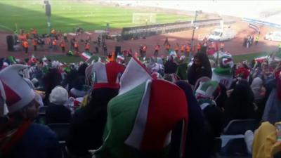 Female football fans cheer as they attend the World Cup qualifier against Cambodia