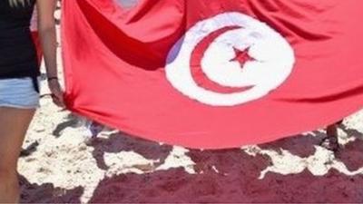 Tourists carry Tunisian flag after terror attack