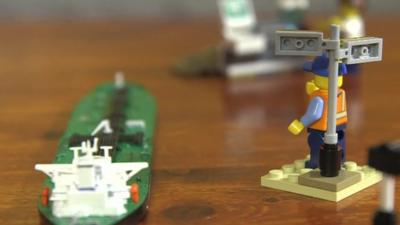 Lego man directing an oil tanker