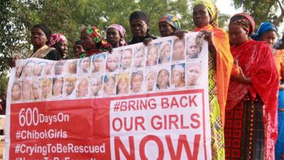 Members of the "Bring Back Our Girls" movement, holding a banner showing photographs of some of the missing