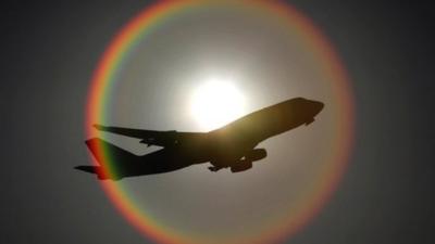 File image of an aeroplane flying in front of the sun as it departs Heathrow airport