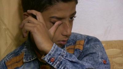 Syrian boy, wiping a tear from his eye