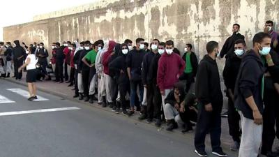 Migrants wait near the emergency camp in Gran Canaria