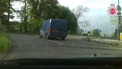 Blue van swerving across the road