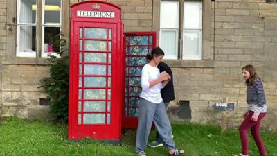 Children using phonebox as book swap