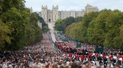 Mourners watch the State Hearse of Queen Elizabeth II as it drives along the Long Walk