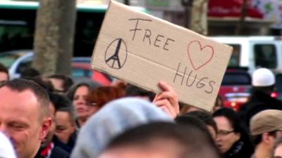 Cardboard sign with 'Free Hugs' written on it