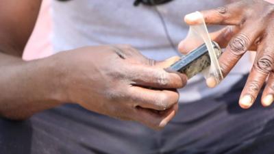 Fisherman puts condom around a mobile phone