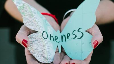 An artist holding a map shaped like a butterfly