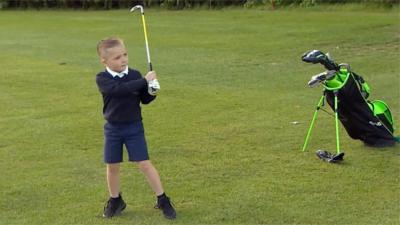 Young boy playing golf