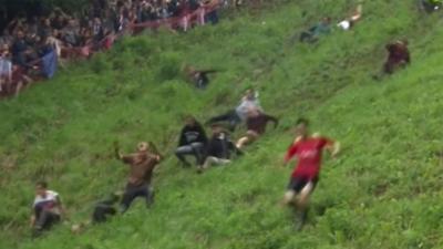 Competitors race down hill in cheese-rolling contest