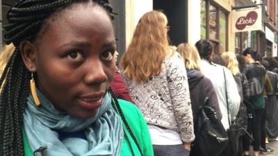 Woman speaking in front of queue